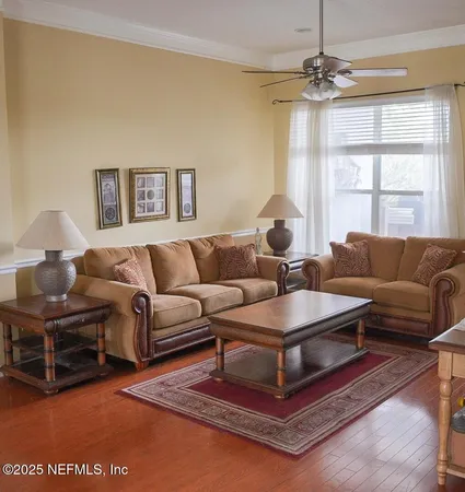a living room with furniture a chandelier and a window