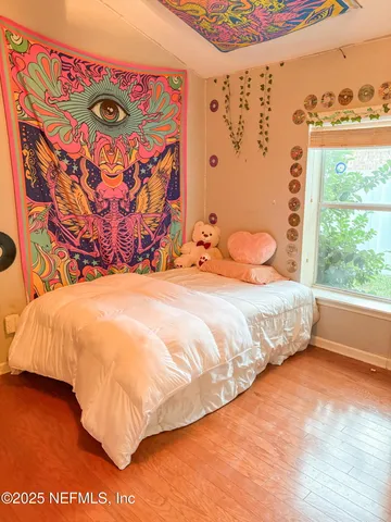 a bedroom with a bed and a painting on the wall
