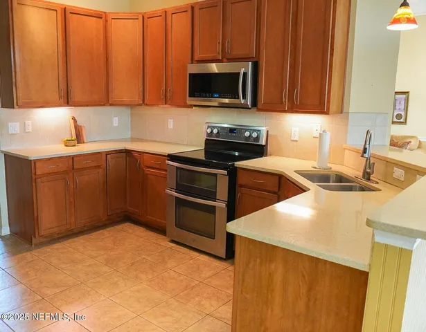 a kitchen with stainless steel appliances a stove a sink a microwave and cabinets