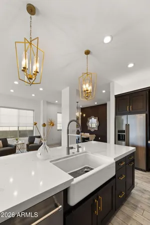 a kitchen with stainless steel appliances granite countertop a stove top oven a refrigerator a sink and a dining table with wooden floor