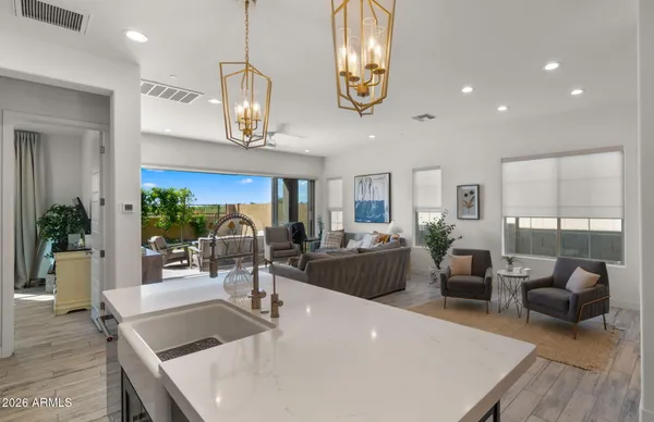 a kitchen with stainless steel appliances a dining table chairs refrigerator and microwave