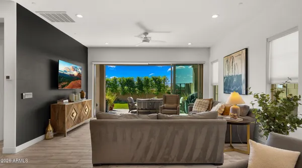 a kitchen with stainless steel appliances a sink a stove a center island and living room view