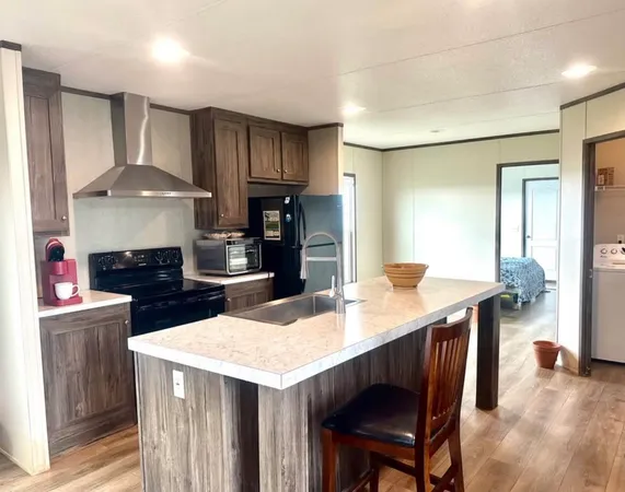 a kitchen with a stove a refrigerator and a dining table