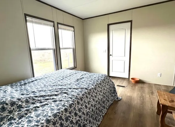 a bedroom with a bed and wooden floor