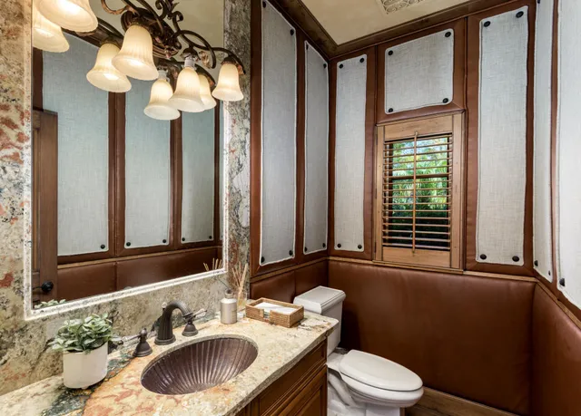 a bathroom with a granite countertop sink mirror vanity and toilet