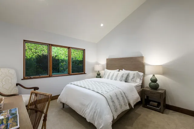 a large bed sitting in a bedroom next to a window