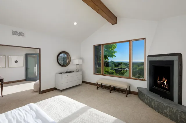 a living room with furniture fireplace and a large window