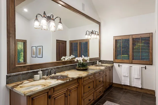a bathroom with sinks granite countertop double vanity and a mirror
