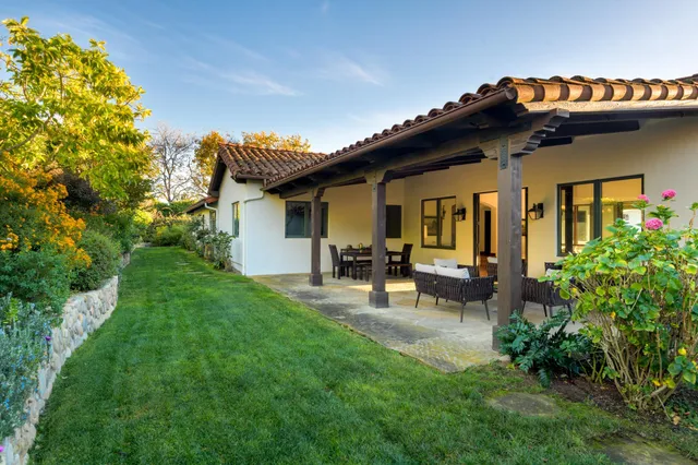 a view of house with backyard and sitting area