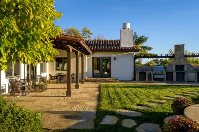 a view of a house with swimming pool and sitting area