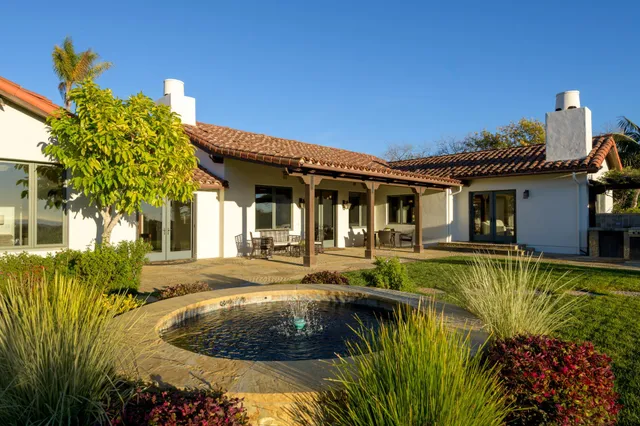 a view of a house with pool and sitting area