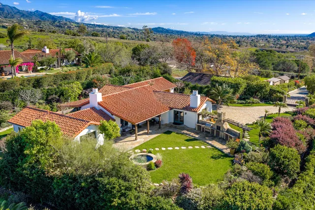 an aerial view of a house with garden space and outdoor seating