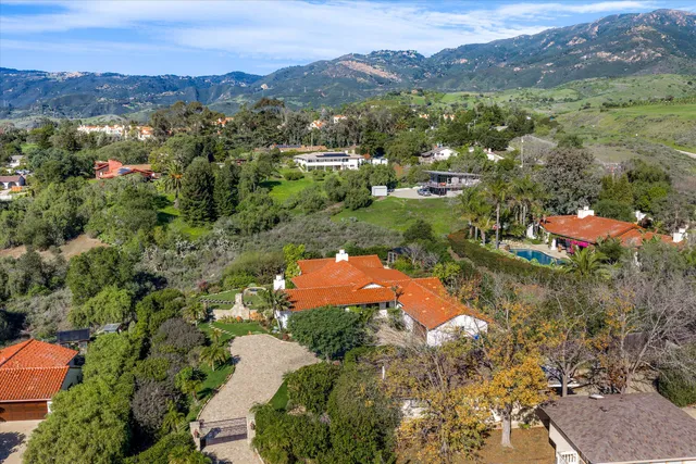 an aerial view of residential houses with outdoor space and trees