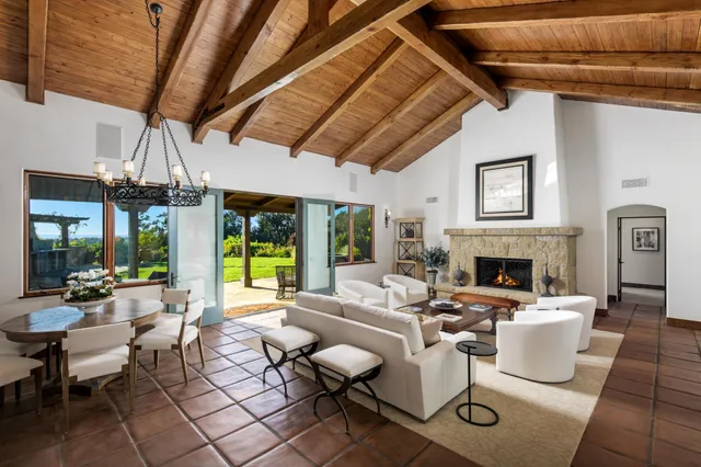 a living room with fireplace furniture and a large window