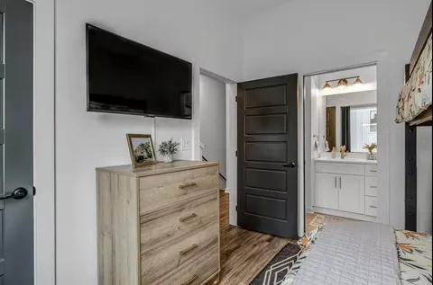 a room with a flat screen tv and dresser