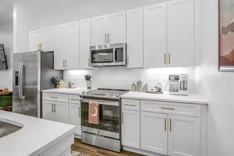 a kitchen with white cabinets stainless steel appliances and sink