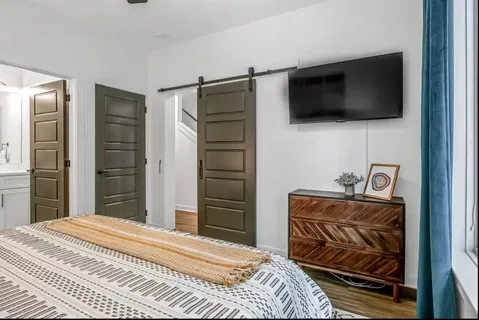 a bedroom with a bed and a flat screen tv