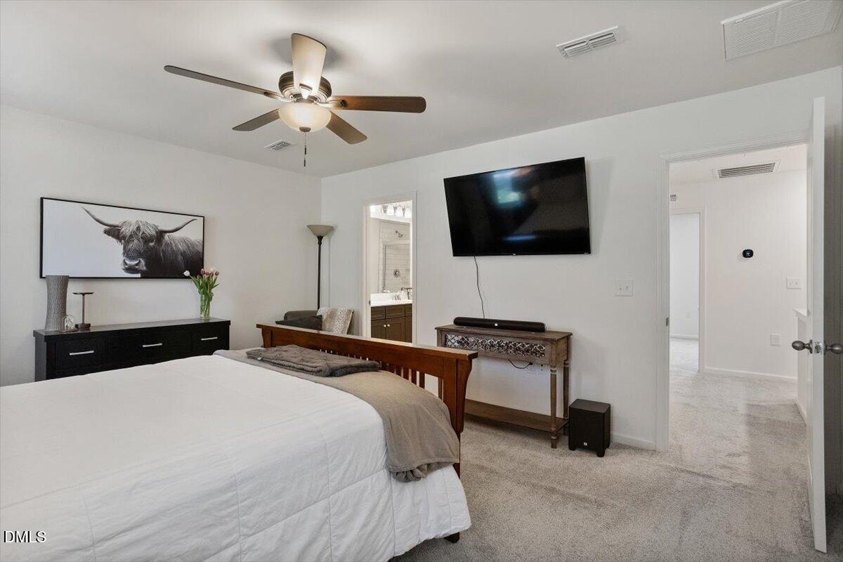 517 Hacksaw Trail Raleigh, NC 27610 - Photo 13 of 20 a bedroom with a bed a flat screen tv and a couch