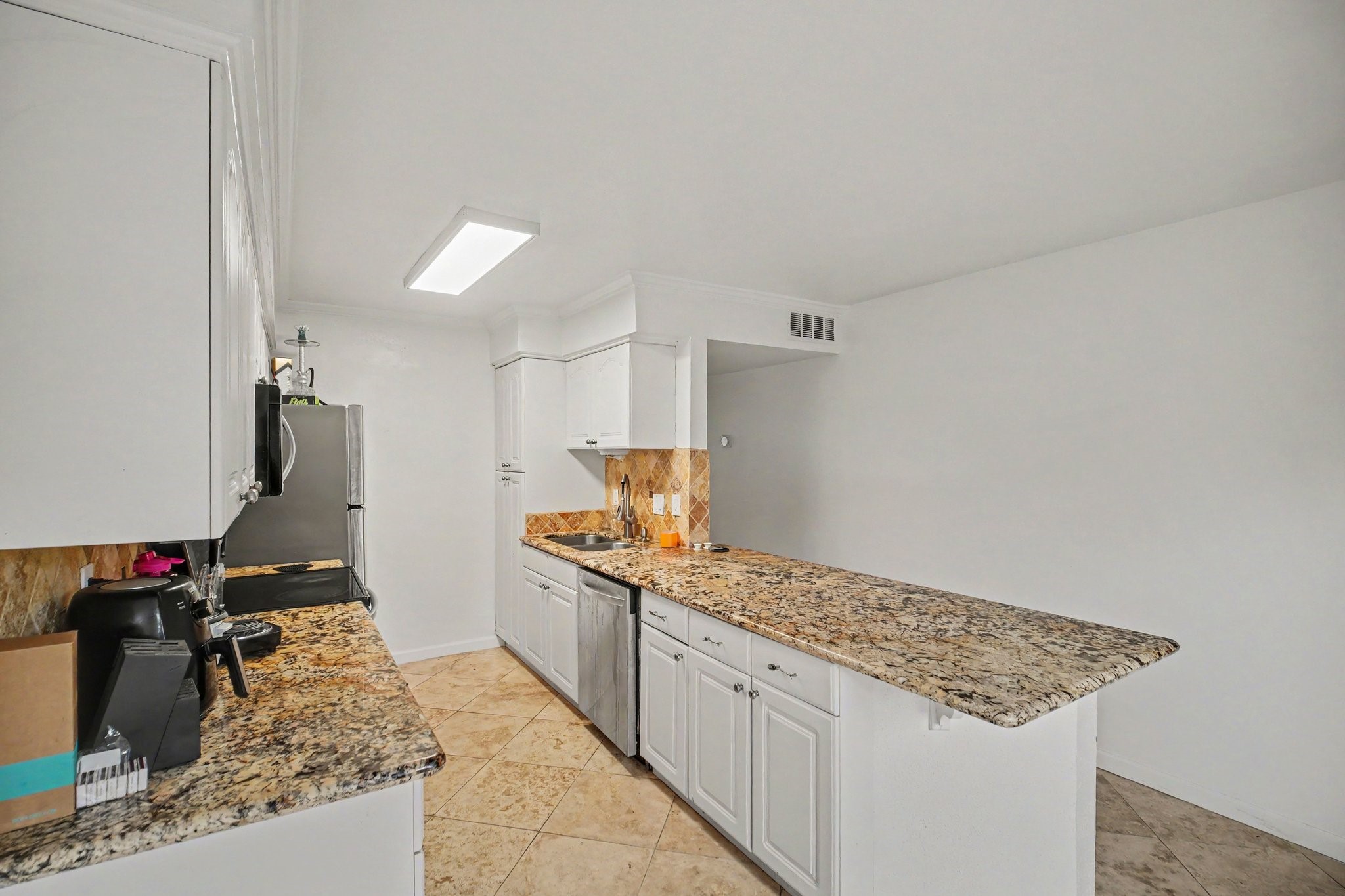 5801 Lumberdale Road, Unit 78 Houston, TX 77092 - Photo 8 of 35 Experience culinary delight in this sleek kitchen featuring elegant granite countertops, pristine white cabinetry, and modern stainless steel appliances, all complemented by stylish tile flooring.