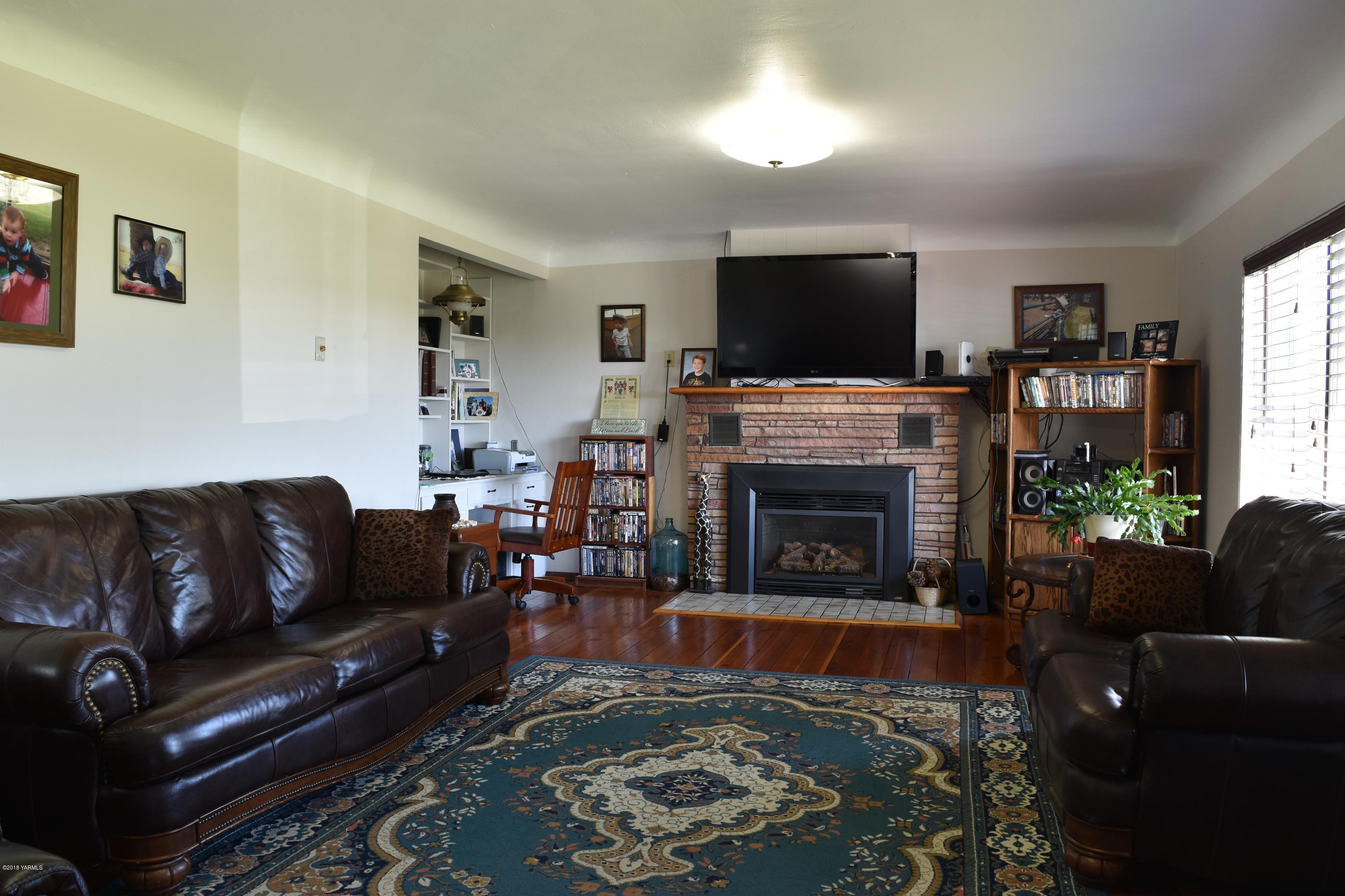 2000 Hiland Road Tieton, WA 98947 - Photo 5 of 16 a living room with furniture a flat screen tv and a fireplace