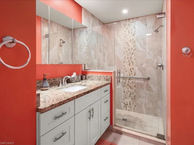 a bathroom with a granite countertop sink and a mirror