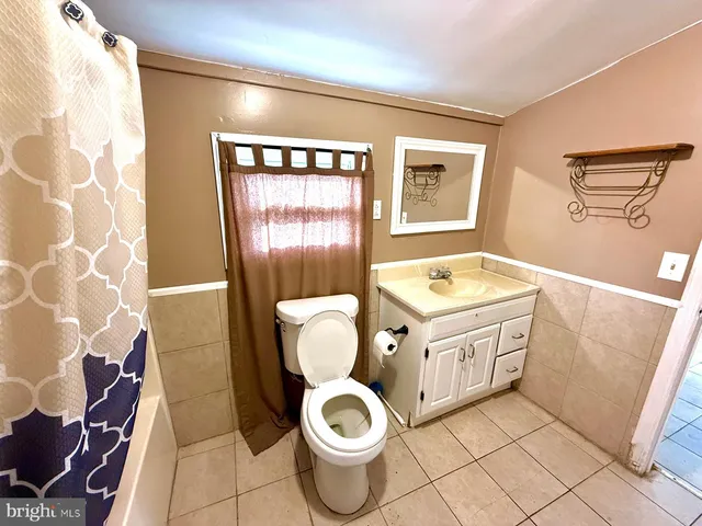a bathroom with a granite countertop toilet sink and mirror