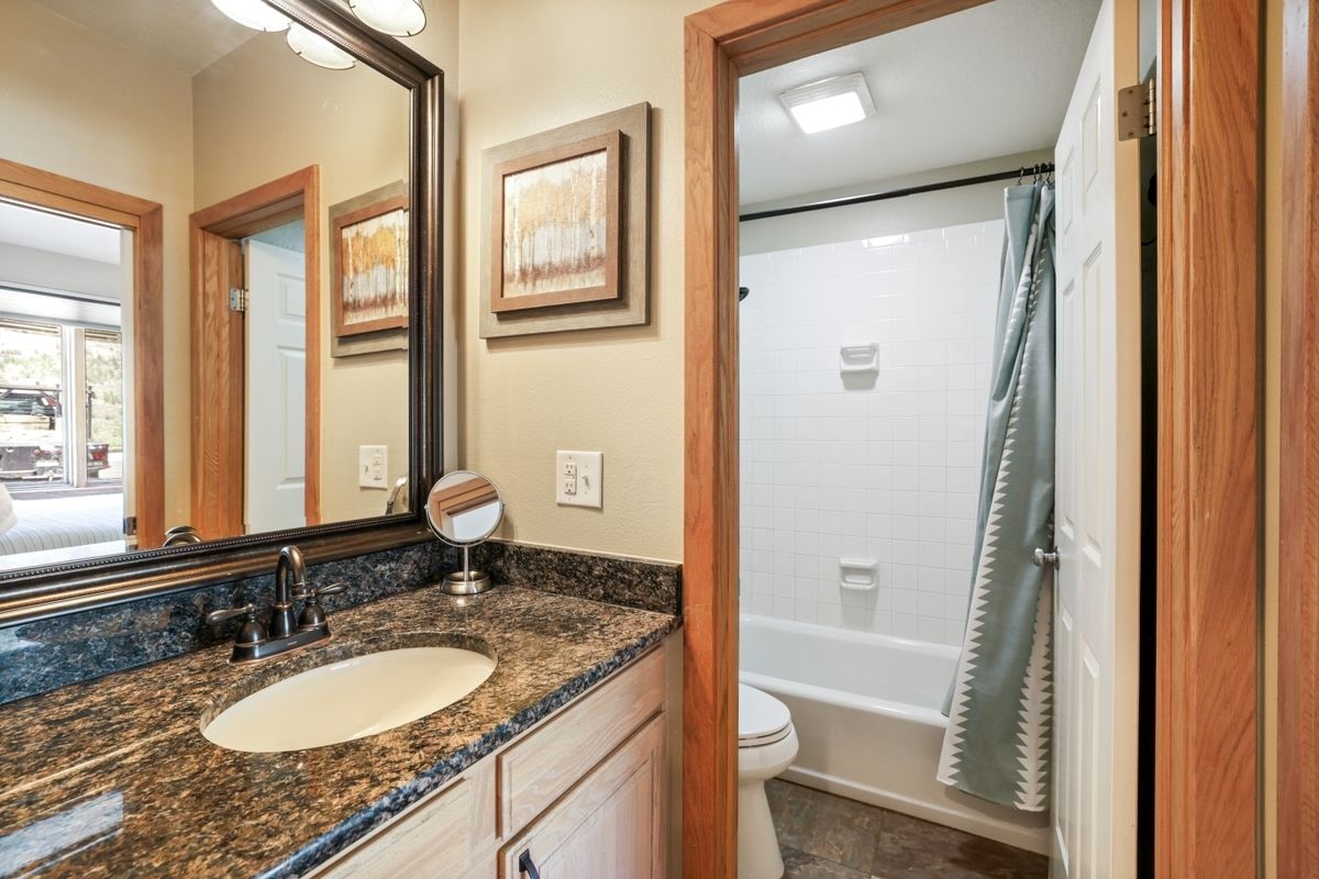 22138 Highway 6, Unit 1553 Keystone, CO 80435 - Photo 16 of 43 a bathroom with a granite countertop sink mirror vanity and a bathtub