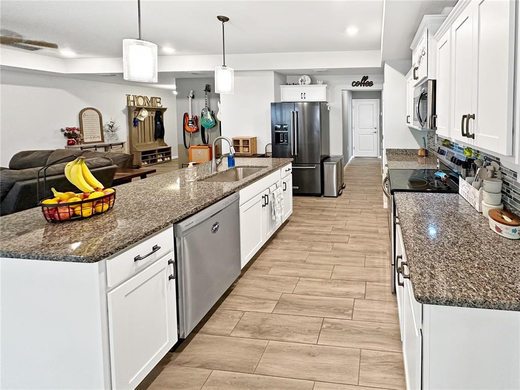 13023 Downy Woodpecker Road Weeki Wachee, FL 34614 - Photo 15 of 43 a large kitchen with stainless steel appliances kitchen island granite countertop a large counter top and a sink