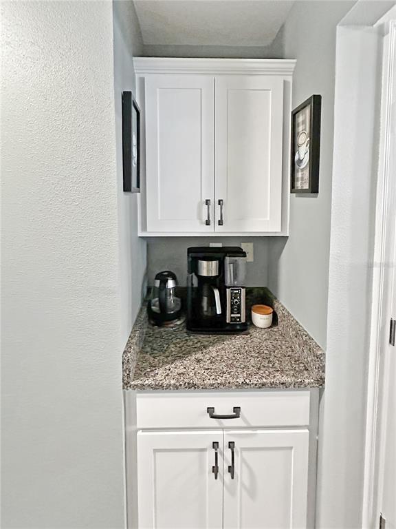 13023 Downy Woodpecker Road Weeki Wachee, FL 34614 - Photo 17 of 43 a kitchen with granite countertop white cabinets and stainless steel appliances