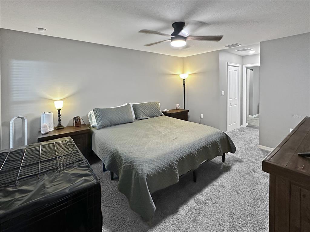 13023 Downy Woodpecker Road Weeki Wachee, FL 34614 - Photo 20 of 43 a bedroom with a bed and a chandelier