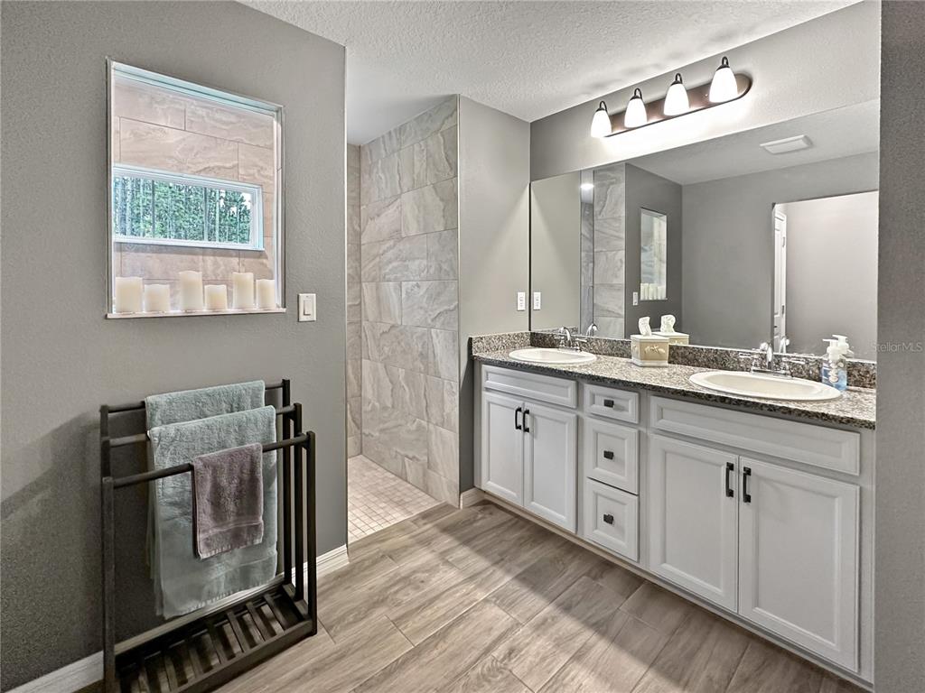 13023 Downy Woodpecker Road Weeki Wachee, FL 34614 - Photo 22 of 43 a bathroom with a double vanity sink and a mirror
