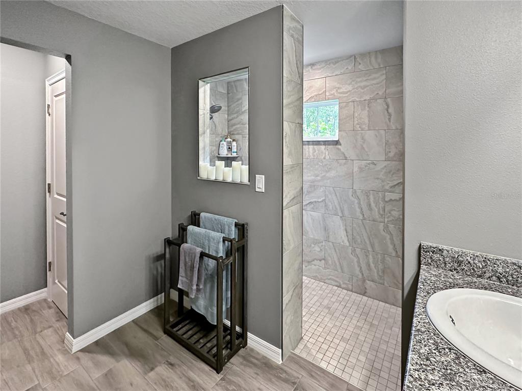 13023 Downy Woodpecker Road Weeki Wachee, FL 34614 - Photo 23 of 43 a bathroom with a sink a mirror and a shower