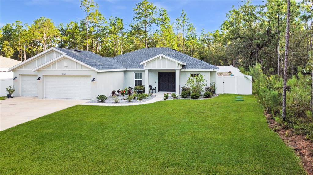 13023 Downy Woodpecker Road Weeki Wachee, FL 34614 - Photo 4 of 43 a front view of a house with garden