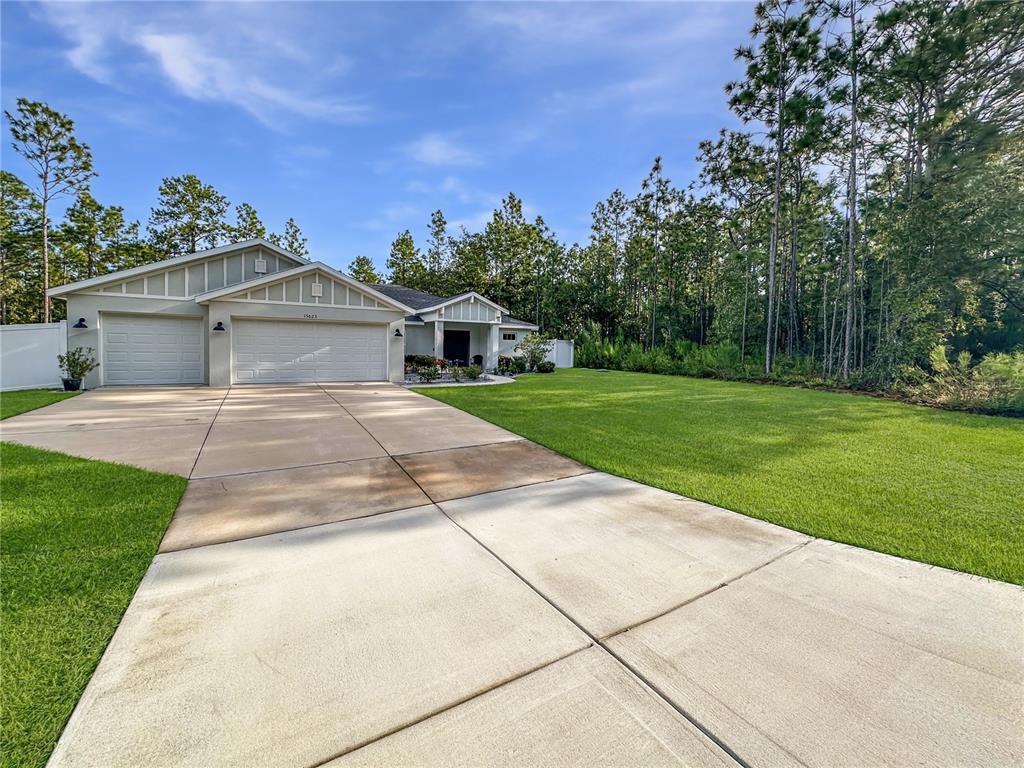 13023 Downy Woodpecker Road Weeki Wachee, FL 34614 - Photo 43 of 43 a front view of a house with a yard and trees