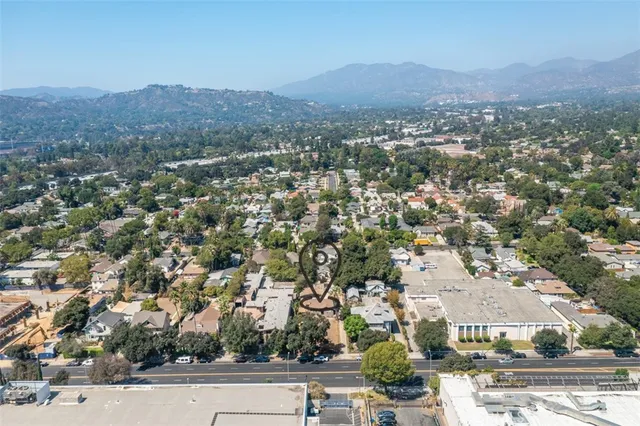 an aerial view of residential houses with outdoor space and trees