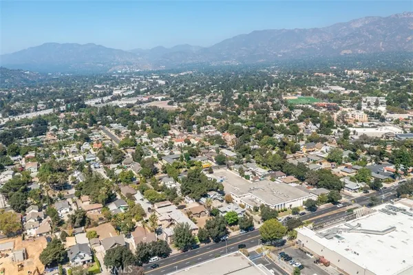 an aerial view of residential houses with outdoor space and trees