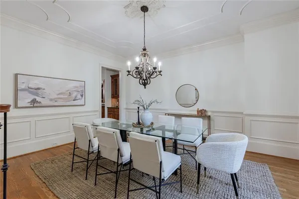 a dining room with chandelier and wooden floor