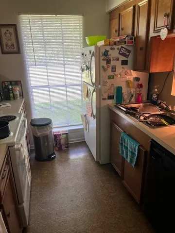 a kitchen with stainless steel appliances a stove a sink a refrigerator and a window