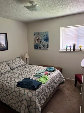 a bedroom with a bed and a painting on the wall