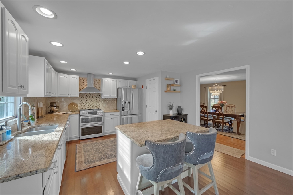 99 Breakneck Road Sturbridge, MA 01566 - Photo 4 of 28 a kitchen with stainless steel appliances granite countertop a stove top oven a sink a dining table and chairs