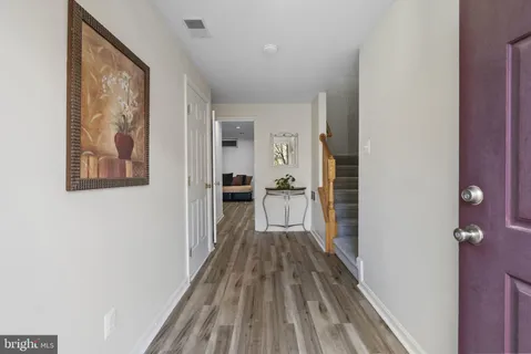 a view of a hallway with wooden floor and staircase