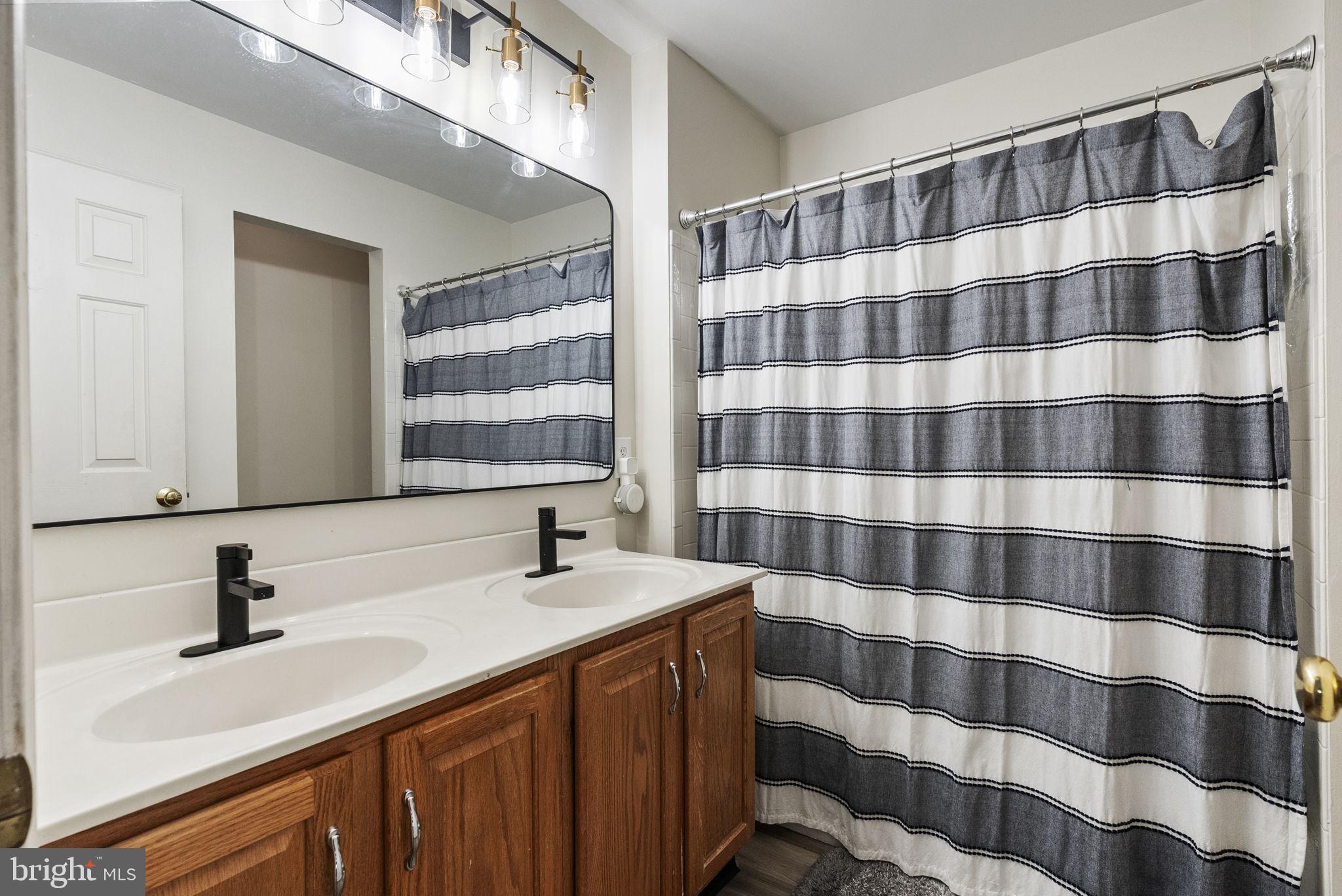 27 Branford Way Coatesville, PA 19320 - Photo 28 of 44 a bathroom with a double vanity sink a mirror a shower and a double vanity