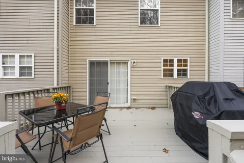 a view of a house with wooden deck and furniture