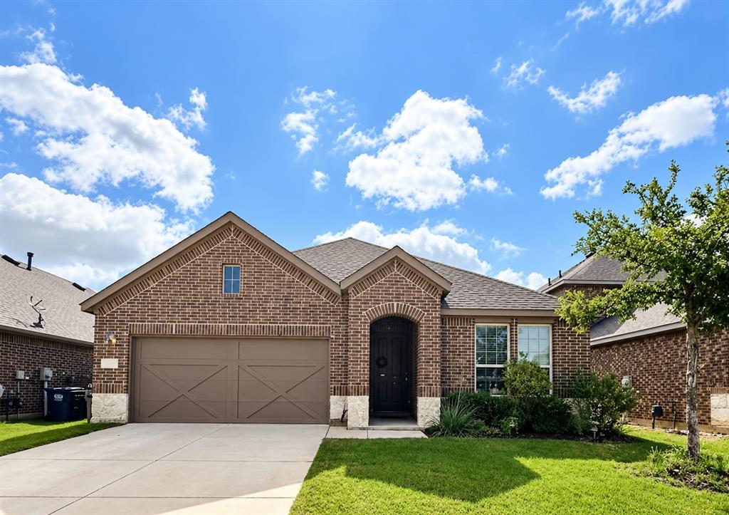 4620 Karhold Road Little Elm, TX 76227 - Photo 1 of 8 Brick exterior with stone accents, arched entryway, attached garage with decorative doors, and mature landscaping