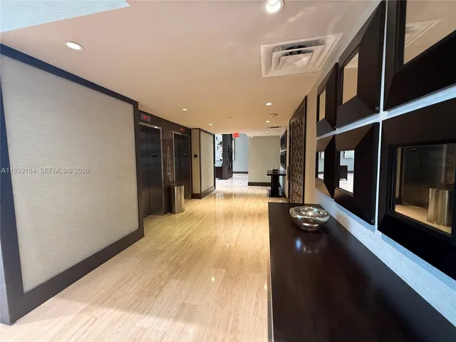 a view of a hallway with wooden floor and furniture