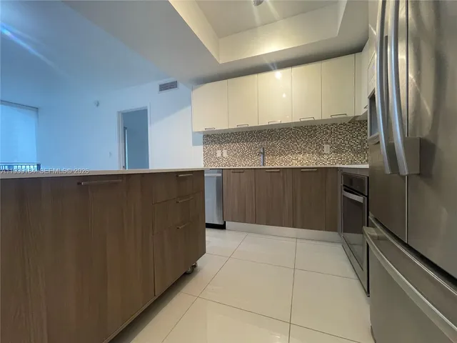 a kitchen with a refrigerator and a sink