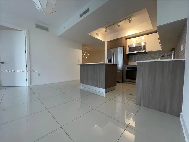 a kitchen with granite countertop a refrigerator and a stove top oven