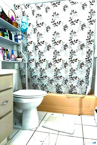 a bathroom with a toilet and a shower curtain