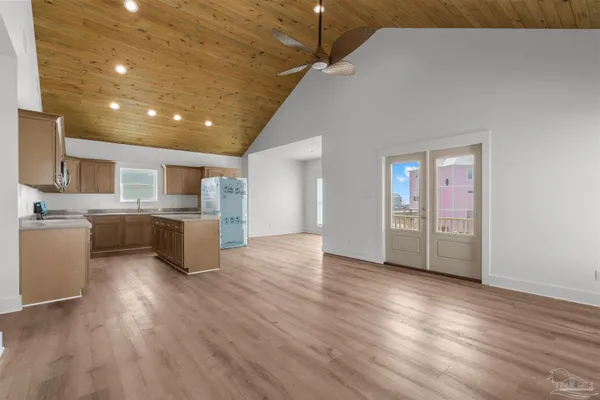 a view of a kitchen with a sink and dishwasher a refrigerator with wooden floor
