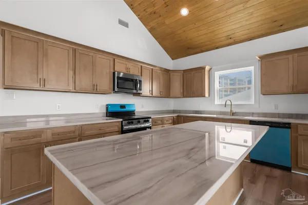 a kitchen with granite countertop a stove a sink and a microwave